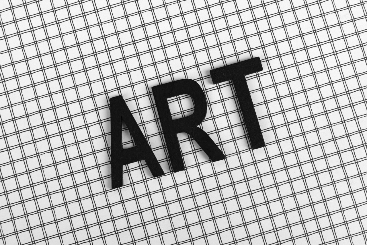 Black letters spelling ART on a black and white grid pattern creates a conceptual visual.